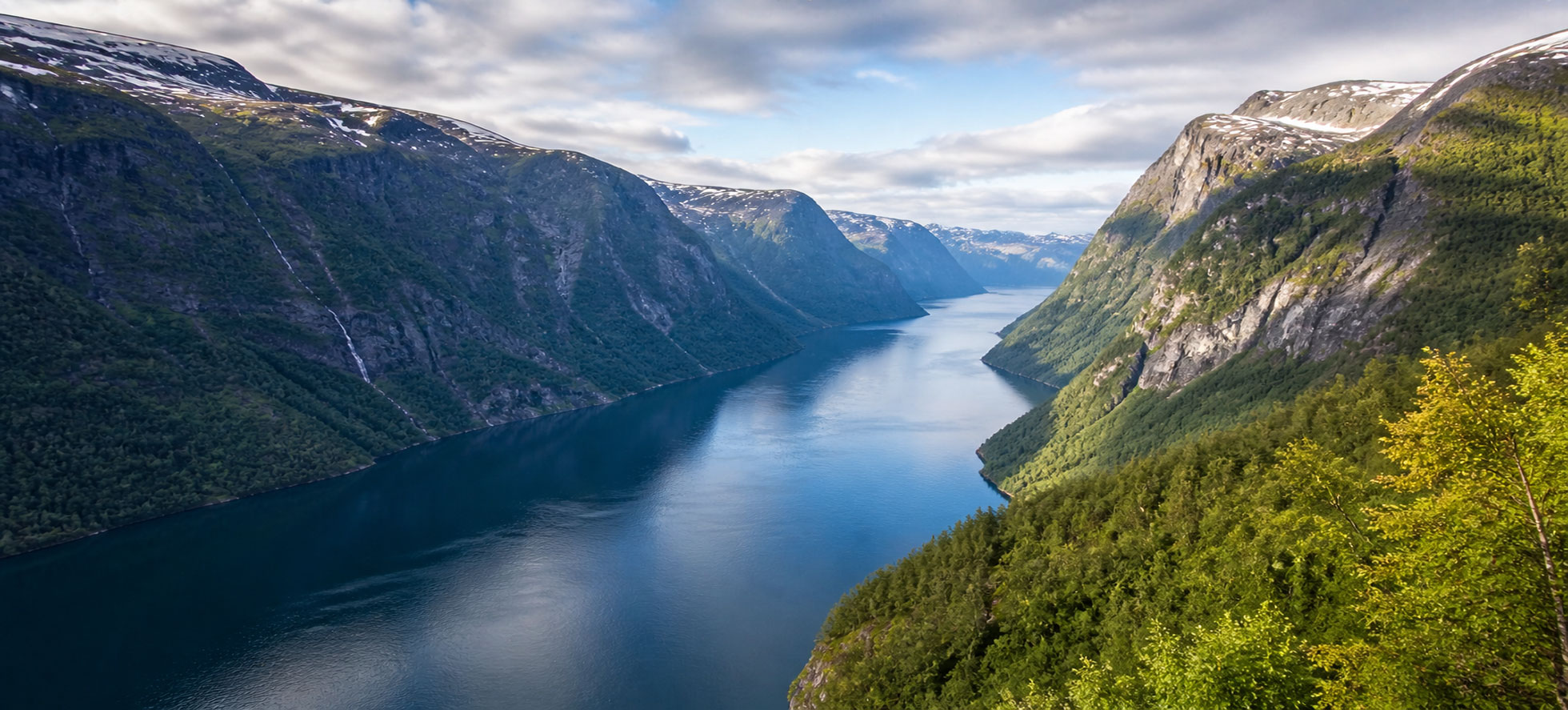 Norwegian Fjords cruise with dramatic cliffs, waterfalls, and deep blue water
